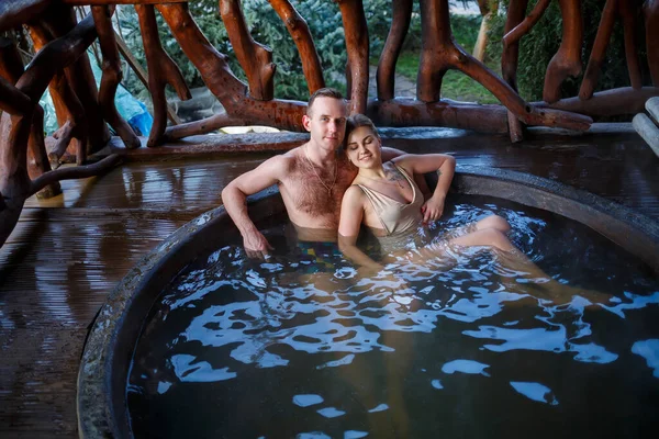 夏のリゾート地で自然のぼやけた背景でロマンチックな休暇にジャグジーでお風呂に入る幸せなロマンチックなカップル 屋外ジャグジー — ストック写真