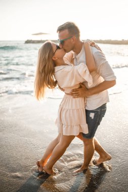 Birbirine aşık bir çift deniz kenarında sahilde yürüyor. Akdeniz kıyısında gün batımında genç bir aile. Yaz tatili kavramı