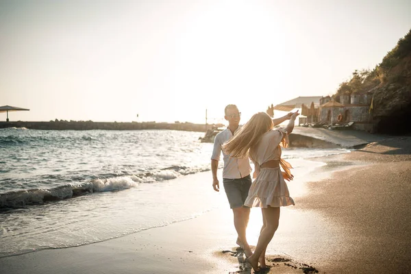愛のカップルは海の近くのビーチを歩いています 地中海に沈む夕日の若い家族 夏休みのコンセプト — ストック写真