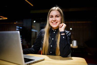 Modern kadın işadamının normal çalışma günü. İşyerinde otururken dizüstü bilgisayarda çalışan güzel bir genç kadın.