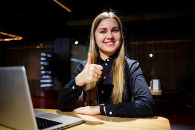 Modern kadın işadamının normal çalışma günü. İşyerinde otururken dizüstü bilgisayarda çalışan güzel bir genç kadın.