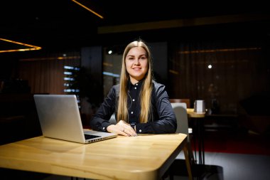 Modern kadın işadamının normal çalışma günü. İşyerinde otururken dizüstü bilgisayarda çalışan güzel bir genç kadın.