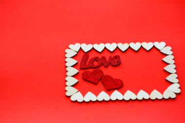 Sevgililer Günü geçmişi. Tahta kalpler kırmızı bir arka planda dikdörtgenle kaplıdır. Kalpli yazılar için yer vardır. Kartpostallar için kalpler.