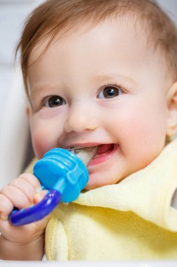 Küçük bir çocuk yüksek bir sandalyeye oturur ve ağdan meyve yer. Bebekleri beslemek için Nibbler