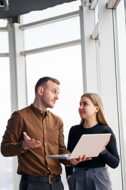 Başarılı bir kadın ofis çalışanı ve netbook 'u olan bir meslektaşı şehre bakan bir pencerenin önünde bir gökdelende duruyorlar. Şehir mimarları dizüstü bilgisayara bakıyor projeden memnun