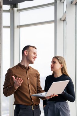 Başarılı bir kadın ofis çalışanı ve netbook 'u olan bir meslektaşı şehre bakan bir pencerenin önünde bir gökdelende duruyorlar. Şehir mimarları dizüstü bilgisayara bakıyor projeden memnun