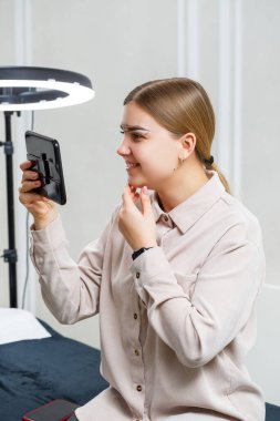 Makyöz, genç bir kızın kalıcı makyajı için kaş boyası uyguluyor. Profesyonel makyaj ve kozmetik bakım.