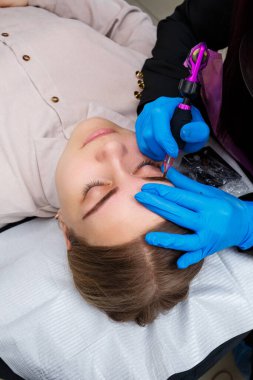 Güzellik salonunda gür kaşları olan güzel bir kadının yüzü. Kaşlar için kalıcı makyaj. Güzellik uzmanı kadınlar için kaş dövmesi yapar. Güzellik prosedürü.