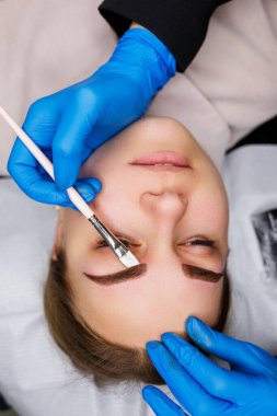 Kaşlarında kalıcı makyaj dövmesi olan bir kadın. Güzellik uzmanı kaşların bir taslağını çiziyor. Profesyonel makyaj ve estetik cilt bakımı.