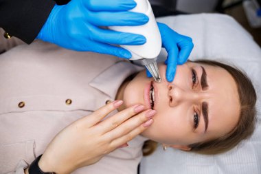 Yüzünde kalıcı makyajın lazerle çıkarılması. Dövme yaptıran genç bir kadının yakın çekimi. Yüzündeki doğal kusurların düzeltilmesi.