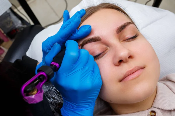 Güzellik salonunda gür kaşları olan güzel bir kadının yüzü. Kaşlar için kalıcı makyaj. Güzellik uzmanı kadınlar için kaş dövmesi yapar. Güzellik prosedürü.