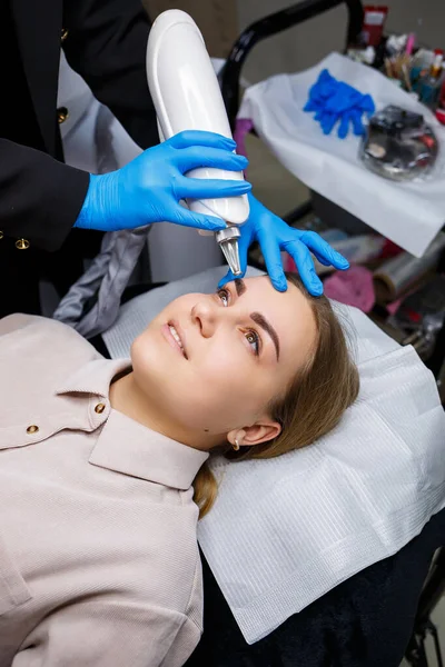 Yüzünde kalıcı makyajın lazerle çıkarılması. Dövme yaptıran genç bir kadının yakın çekimi. Yüzündeki doğal kusurların düzeltilmesi.