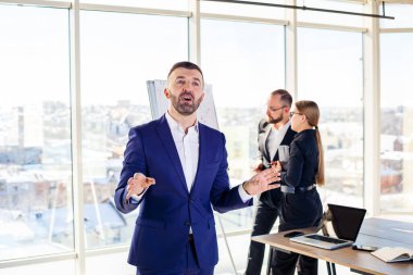 Başarılı bir erkek akıl hocası, yönetmen, ofiste takım elbiseli bir iş adamı. Çalışma günü konsepti. Ön planda patronla takım toplantısı var.