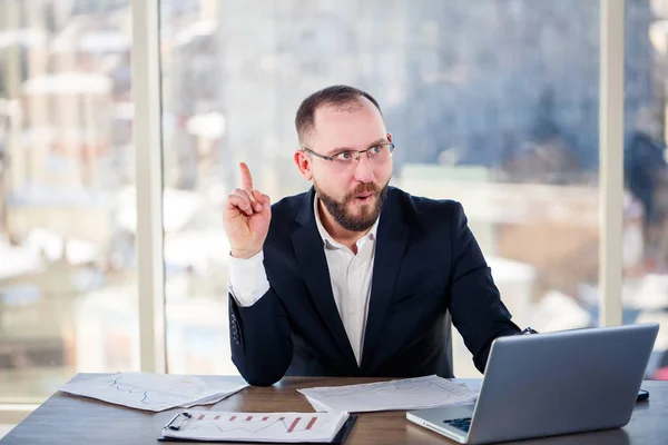 The corporate madman is sitting at the computer in the office and going crazy, the emotional portrait of the man at the table. Crazy worker at his workplace