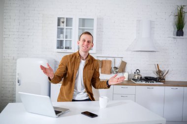 Mutfaktaki masada uzaktan kumandayla çalışan yakışıklı genç bir iş adamı. Mutlu bir insan sosyal ağda iletişim kurar, internette bilgi arar..