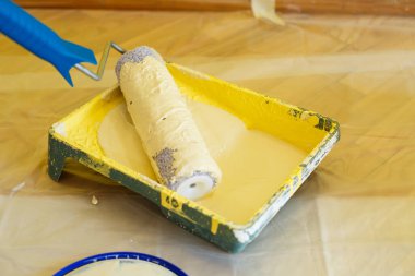 Kapalı alanda çalışırken boya silindirinin yakın plan çekimi, yenileme çalışmaları