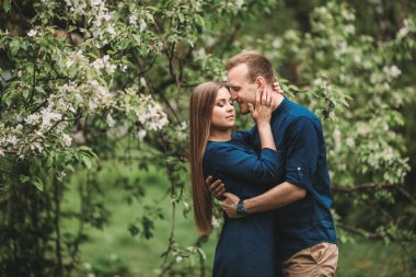Bahar bahçesinde elinde kız olan yakışıklı bir genç. Romantik çift parkta yürüyor. Mutlu İlişkiler