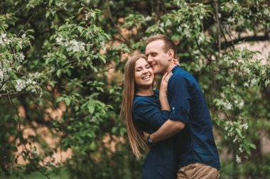 Bahar bahçesinde elinde kız olan yakışıklı bir genç. Romantik çift parkta yürüyor. Mutlu İlişkiler