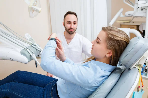 一位专业牙医与一位女病人交流 牙科诊所为病人检查 牙科治疗过程的讨论 — 图库照片