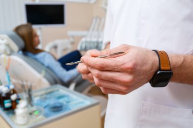 Dişçinin işyeri. Doktor demir bir diş aleti aldı. Diş hekimi kavramı.