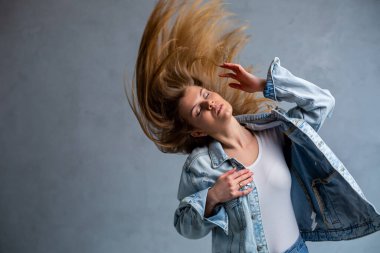 Güzel bir genç kadının portresi. Bir kızın duygusal hüzünlü fotoğrafı. Beyaz tişört ve kot ceket giymişti.