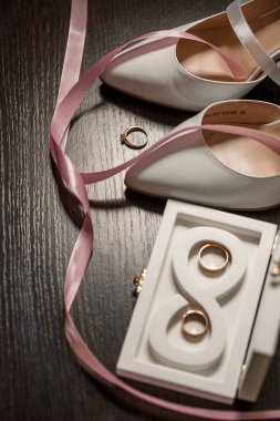 Gelin için düğün ayakkabıları. Alyansların yanında yüksek topuklu ayakkabılar, düğün mücevherleri. Evlilik kavramı