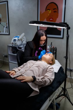 Güzellik salonunda gür kaşları olan güzel bir kadının yüzü. Kaşlar için kalıcı makyaj. Güzellik uzmanı kadınlar için kaş dövmesi yapar. Güzellik prosedürü.
