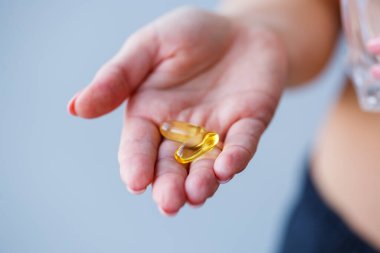 Haplarla el ele. Kadın bağışıklığı geliştirmek için ilaç alıyor. Günlük vitamin normu, etkili hazırlıklar, modern sağlık eczanesi.