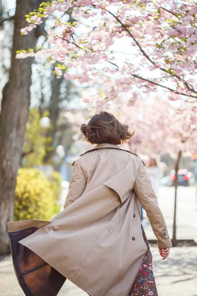 桜の花を背景に優しい女性の肖像画 開花する桜の庭を歩いてください 桜公園に立って美しさを楽しむ若いスタイリッシュな女性 — ストック写真