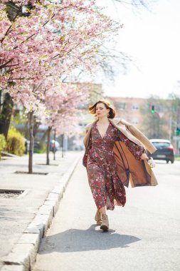 Baharda, bir kadın sakura ağaçlarıyla birlikte çiçek açmış bir cadde boyunca yürür. Çiçek açan ağaçların arasında uzun ipek ve zarif bir elbise giyen bir kız yürüyor.