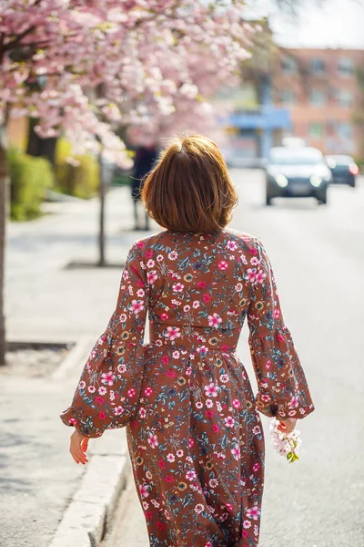 桜の花を背景に優しい女性の肖像画 開花する桜の庭を歩いてください 桜公園に立って美しさを楽しむ若いスタイリッシュな女性 — ストック写真