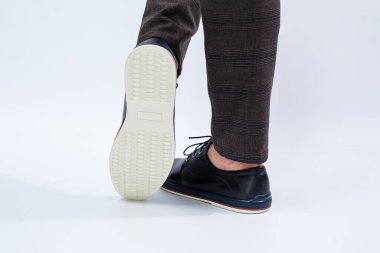Bir adam dantelli doğal deriden yapılmış klasik siyah ayakkabılar giyiyor. İş hayatı yaşayan erkekler için ayakkabılar. Yüksek kalite fotoğraf