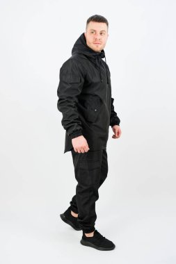 Modern siyah bir kıyafet giyen modaya uygun bir birey, rahat ve stili harmanlayan bir poz veriyor. Şehir maceraları ya da arkadaşlarla rahat buluşmalar için ideal..