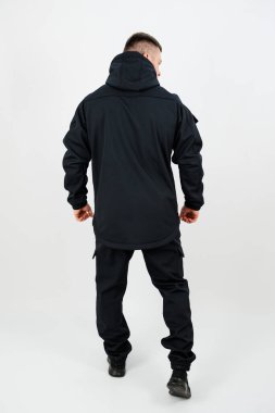 Bir insan arkasını dönmüş, şık bir siyah kapüşonlu ve uyumlu pantolonu olan, şehir ortamlarında sıradan geziler ya da maceraperest anlar için mükemmel bir şekilde sergiliyor..