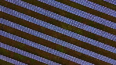 Güneş panelleri, yeşil bir alana yerleştirilmiş güneş ışığını yakalayarak çarpıcı bir örüntü oluştururlar. Kurulum yenilenebilir enerji ve çevre bakımına olan bağlılığını gösteriyor.