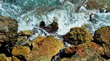 Güçlü dalgalar kayalık bir kıyı şeridine çarparak okyanusun doğal güzelliğini ve dinamik enerjisini ortaya çıkarıyor. Çarpışan dalgaları olan güzel kayalık kıyı şeridi.