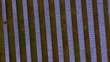 Geniş güneş panelleri açık mavi gökyüzü altında daha parlak bir gelecek için temiz enerji üretmek için güneş ışığını yakalıyor..