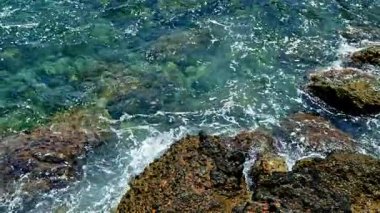 Güçlü dalgalar kayalık bir kıyı şeridine çarparak okyanusun doğal güzelliğini ve dinamik enerjisini ortaya çıkarıyor. Çarpışan dalgaları olan güzel kayalık kıyı şeridi.