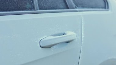 Arabanın kapı kolu dondu. Beyaz karlı buzlu araba kapısı. Araba kışın dışarıda dururken dondu..