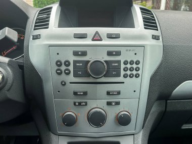 Ses ve iklim ayarlarını denetleyen, kullanılabilirliği ve modern tasarım unsurlarını vurgulayan temiz bir yerleşim gösteren bir araç gösterge panelinin ayrıntılı bir görüntüsü.