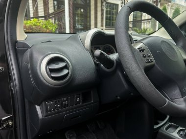 Bir arabanın iç mekanına yakından bakmak ergonomik olarak tasarlanmış direksiyon ve kontroller, büyüleyici bir evin dışındaki işlevsellik ve konforu vurguluyor..
