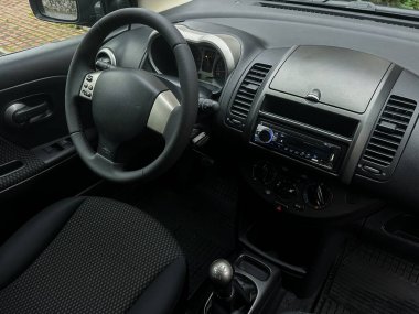 Küçük bir arabanın içinde minimalist bir gösterge paneli ve direksiyon rahat bir atmosfer yaratır. Vites değişimi, sürüş zevki ve ulaşılabilirliğe odaklanmayı vurguluyor.