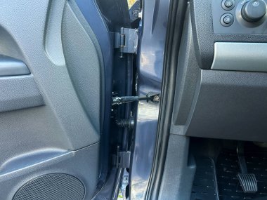 Bir araba kapısı menteşesi, ayrıntılı detaylar ve sağlam inşaatın altını çizerek yakın plan çekilir. Sahne, aracın iç kısımlarını, estetik ve pratik özellikleri harmanlayarak ortaya çıkarıyor..