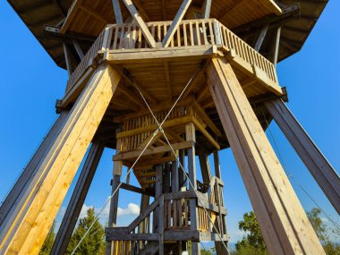 Göz kamaştırıcı ahşap bir gözlem kulesi manzaranın üzerine yükseliyor ve ayrıntılı işçiliğini sergiliyor..