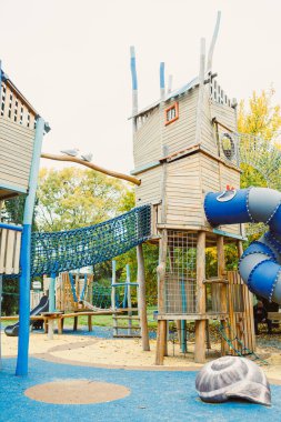 Parlak renkli oyun parkında ahşap oyun evleri, bir kaydırak ve tırmanma ağları, çocukların birlikte keşfetmeleri ve oynamaları için eğlenceli ve güvenli bir ortam sağlıyor..