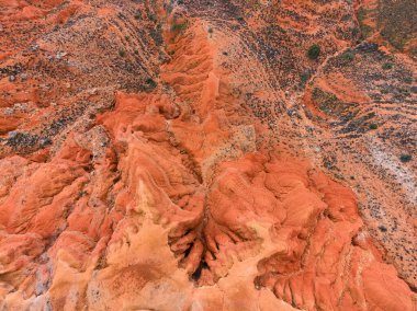 Ziyaretçiler kanyon kaya oluşumlarına yüksek bir bakış açısından bakıyorlar, turuncu araziyi ve çevresindeki coğrafi özellikleri gündüz gözüyle görüyorlar..
