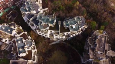 Havadan bakıldığında, terk edilmiş binaların aşırı büyümüş yeşillikler arasında boş durduğu, doğanın kucaklamasındaki ilerlemenin durduğuna dair hikayeler fısıldayan, genişleyen bir inşaat alanı sergileniyor..