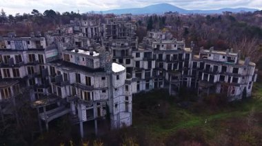 Doğa yeryüzündeki yerini alırken, yeşil alan tarafından tüketilen sessiz yapılar dimdik ayakta duruyor. Uzak bir dağ dramatik bir gökyüzüne doğru yaklaşır ve akıllara durgunluk verecek kadar güzel bir manzara yaratır..