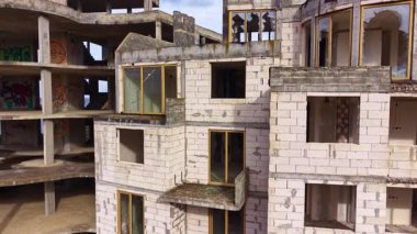 Tamamlanmamış duvarlar ve boş pencereler bu terk edilmiş binada ürkütücü bir atmosfer yaratıyor. Doğa uzayı geri kazanmaya başlıyor, grafiti yüzeyleri süsledikçe, unutulmuş hikayeleri ortaya çıkarıyor..