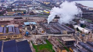 Fabrika, bacadan çıkan dumanla çalışan makineleri gösteriyor. Güneş panelleri çatıya monte edildi. Gündüzleri şehir içi ve yoğun oluyor..